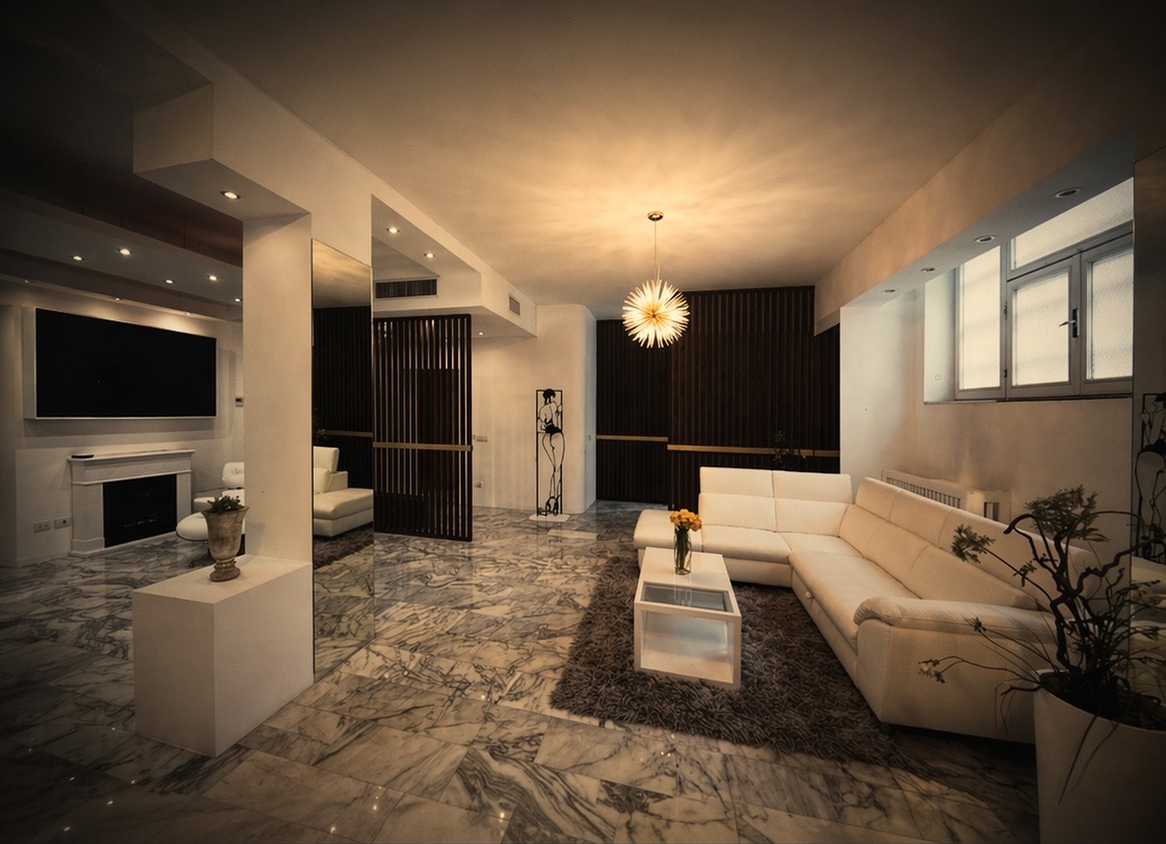 Warm cinematic living room with marble flooring, chandelier glow, wood slat dividers and white sofa
