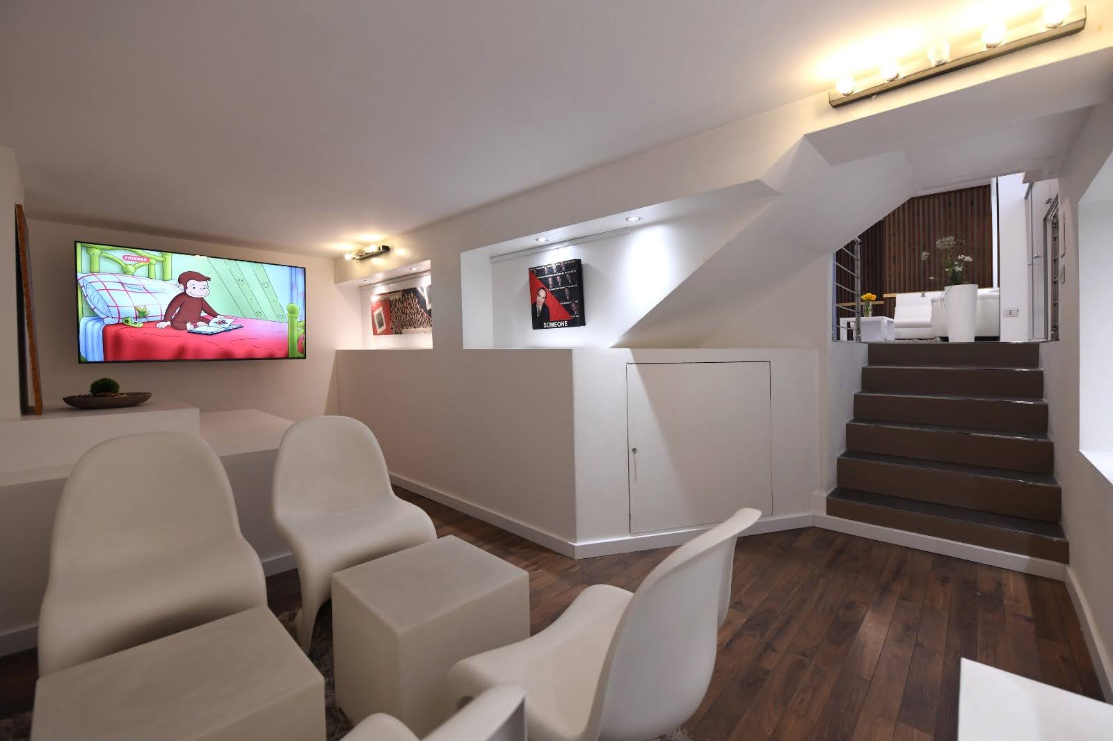 Lower-level private area with lounge seating, stair access and family-friendly space