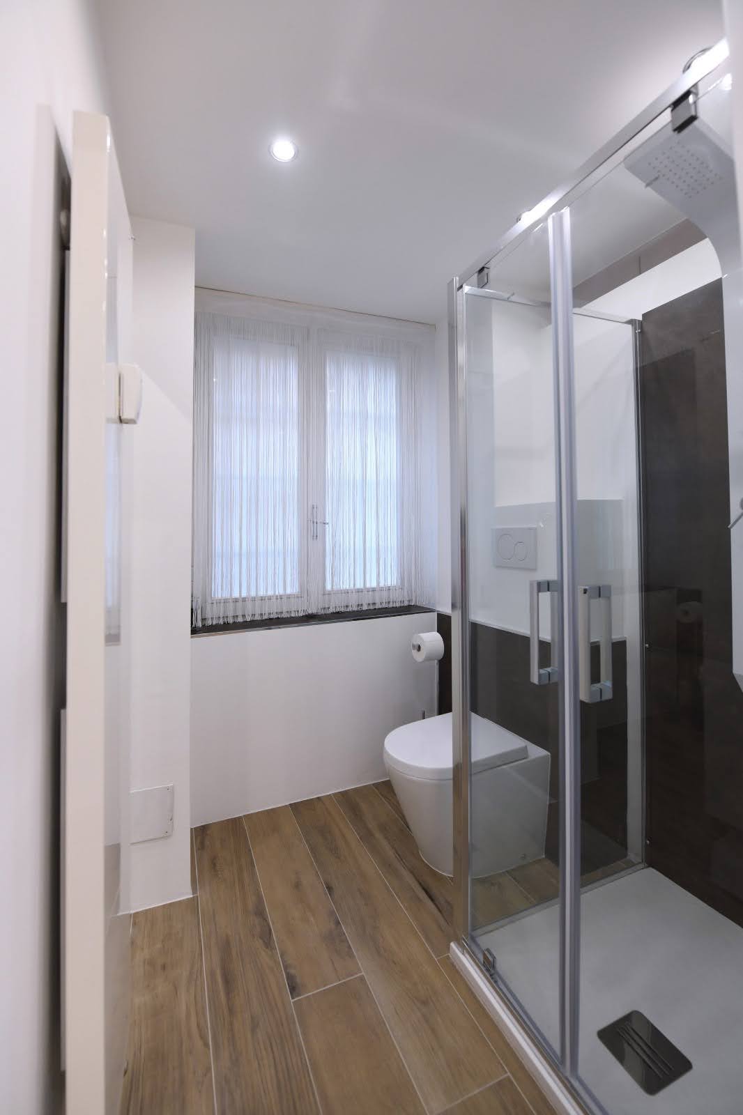 Steam shower detail with warm flooring and natural window light