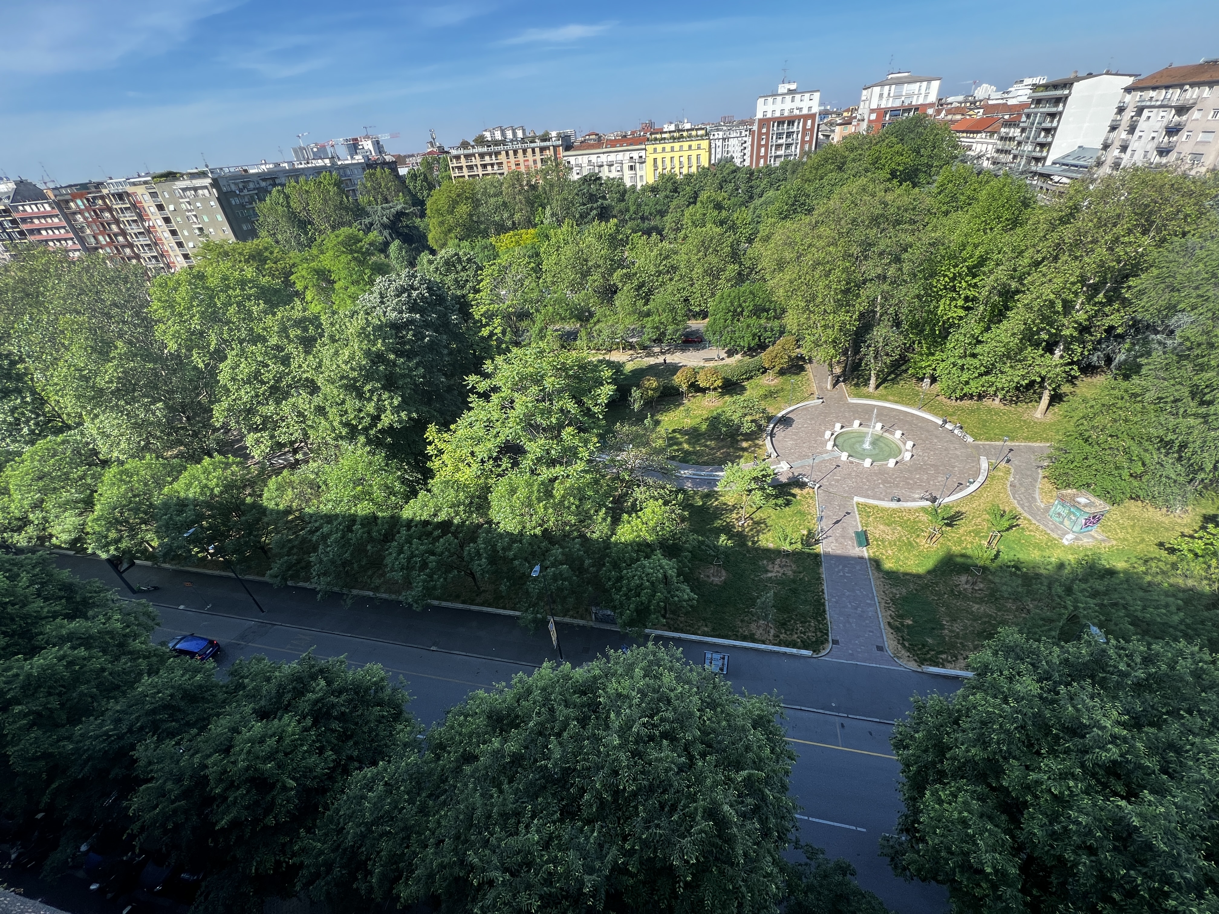 Green residential view near Piazza Napoli in Milan with trees, quiet streets and open park space